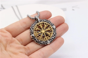 Détail macro du compas Vegvisir doré et du pendentif viking argenté avec chaîne carrée