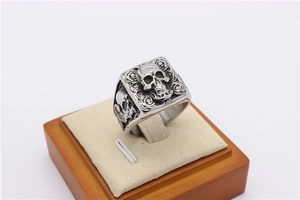 Macro shot of punk style signet ring featuring skull and rose carvings on vintage steel