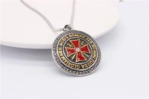 Macro view of vintage shield pendant with red enamel cross and gold embossed text
