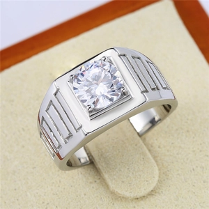 Close-up of a men's silver ring with a large round diamond and geometric engraved patterns