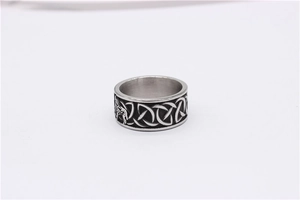 Close-up of vintage steel ring featuring Celtic knot patterns and Viking wolf head relief