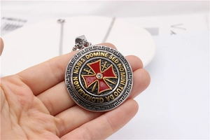 Detail of vintage silver and gold knight templar cross pendant with Latin engraving