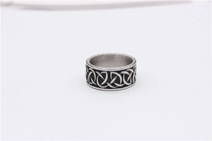 Macro detail of the embossed black Celtic knot pattern on a retro titanium steel men's ring
