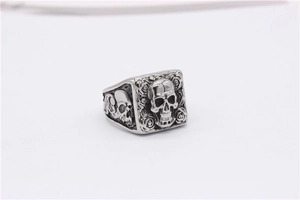 Close-up of vintage punk skull and rose relief on silver-tone titanium steel ring