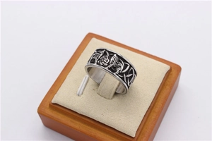 Macro detail of vintage silver men's steel ring with Viking wolf head and Celtic knot carving