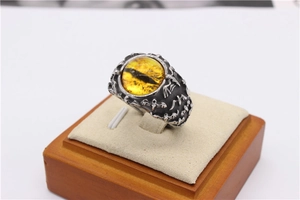 Detailed relief of gothic bat motifs on vintage steel ring with a yellow eye stone