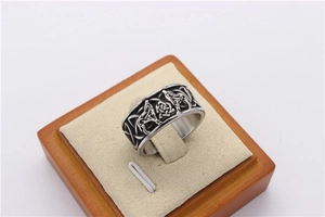 Macro shot of Viking wolf totem and Celtic knot patterns on vintage stainless steel ring