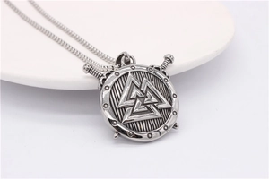 Macro detail of silver Viking shield pendant with Valknut symbol and crossed swords