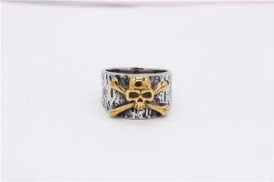 Macro view of punk skull crossbones design on vintage textured stainless steel ring