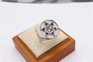 Détail macro d'une bague étoile en argent avec strass colorés et finition mate