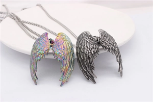 Close-up of fallen angel wing pendants with detailed feather texture in silver and rainbow