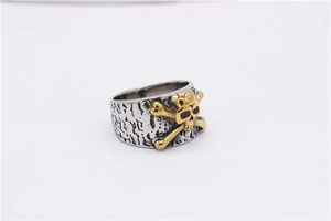 Detailed macro of vintage silver skull ring with gold accent and tree bark texture