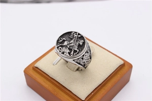 Macro detail of vintage Saint George slaying dragon relief on men's silver ring