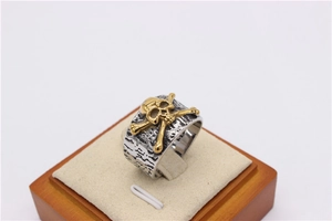 Macro detail of retro skull and crossbones on distressed steel ring band
