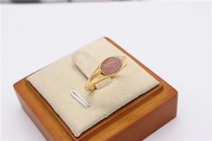 Primo piano dettagliato di un anello minimalista in oro con gemma rosa ovale lucida