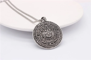 Detailed close-up of retro silver stainless steel necklace with sun god calendar pendant