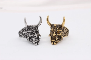 Detailansicht der silbernen und goldenen Hannya-Maskenringe mit aufwendigen Dämonenschnitzereien