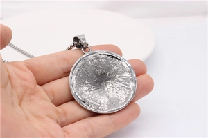 Detailed back view of vintage silver zodiac pendant showing radial metal textures and chain