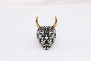 Nahaufnahme eines zweifarbigen Hannya-Maskenrings mit goldenen Hörnern und Silbergesicht