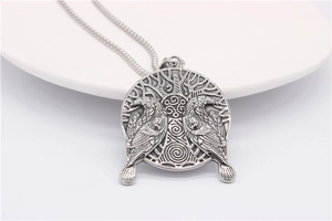 Detailed relief of Viking Odin ravens on round silver pendant with Celtic knotwork