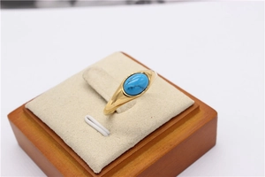Vista macro di un anello dorato vintage con una pietra preziosa ovale a occhio di gatto