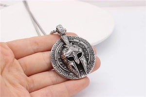 Detail of vintage Spartan helmet shield pendant with Greek key pattern border