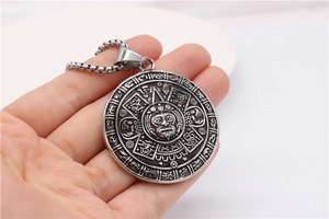 Macro view of retro zodiac compass pendant with intricate Aztec relief patterns