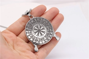 Detail of Viking Vegvisir compass pendant with runes and molten lava edge design