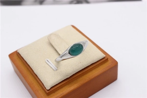 Dettaglio ravvicinato di un anello con gemma verde occhio di gatto su base in velluto