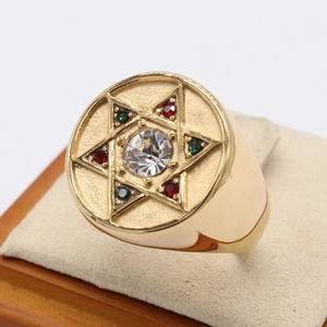 Bague étoile de David dorée ornée de zircons colorés sur un support à bijoux beige