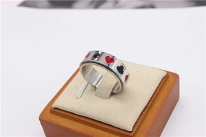 Gros plan d'une bague rotative en acier titane avec motifs de poker colorés en émail