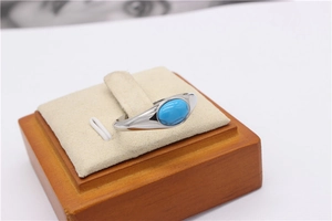 Dettaglio anello turchese ovale retrò con fascia argento su espositore in legno