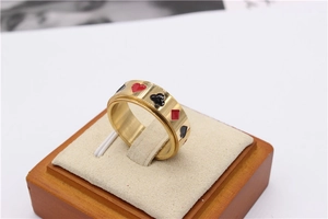Détail d'une bague rotative dorée avec motifs de poker sur un support en velours doux