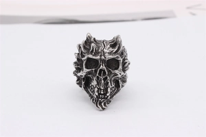 Detailed close-up of retro silver skull ring with gothic punk flame texture and oxidized finish