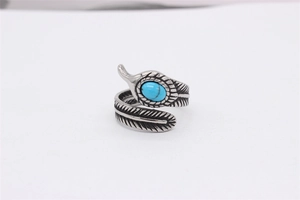 Détail d'une bague plume en acier vintage ornée d'une pierre turquoise bleue