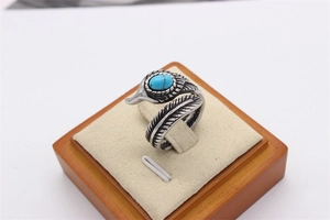 Détails de textures de plumes rétro et pierre turquoise sur bague en acier