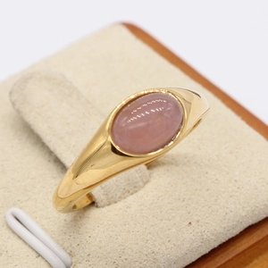 Anello minimalista in oro con gemma occhio di gatto rosa su espositore di velluto