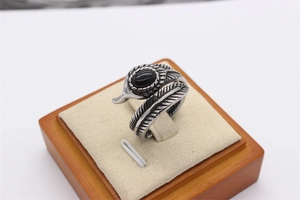 Détail de la bague plume en acier titane vintage avec une pierre noire facettée incrustée
