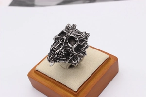 Detailed side view of punk gothic skull ring with vintage silver finish on display stand