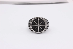 Macro detail of retro nautical titanium steel ring with anchor and compass carvings