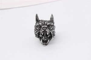Detailed close-up of retro wolf head biting skull design on vintage silver steel ring