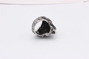 Close-up of vintage wolf head skull ring in oxidized silver finish with embossed textures