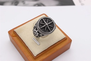 Macro shot of retro nautical steel ring with embossed compass star and helm side detail