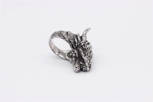 Detailed close-up of a vintage silver dragon head ring with intricate scale carvings