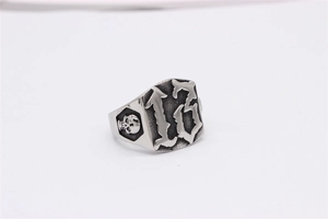 Détail macro d'une bague gothique en acier avec le chiffre 13 et gravures de crâne