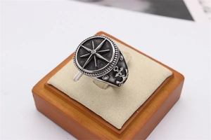 Macro detail of nautical signet ring featuring engraved compass and anchor patterns