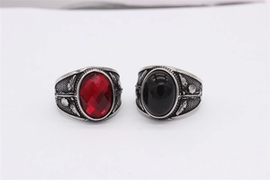 Nahaufnahme von Vintage-Stahlringen mit rotem facettiertem Stein und schwarzem Cabochon