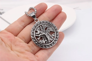Close-up of vintage Tree of Life pendant with Nordic runes in aged titanium steel