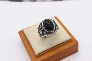 Detailansicht eines Vintage-Herrenrings mit schwarzem Stein und verzierten Gravuren in Silber