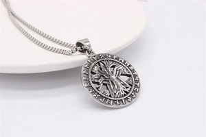 Macro shot of silver viking tree of life pendant with norwegian runes and pentagram detail